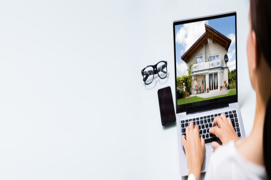 A woman uses real estate software on a laptop.